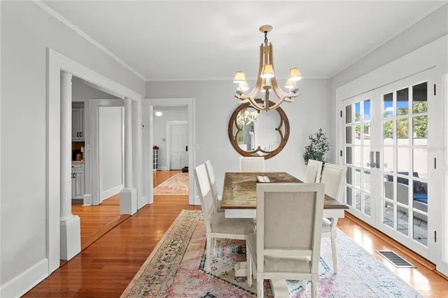 a view of a dining room with furniture a chandelier and wooden floor