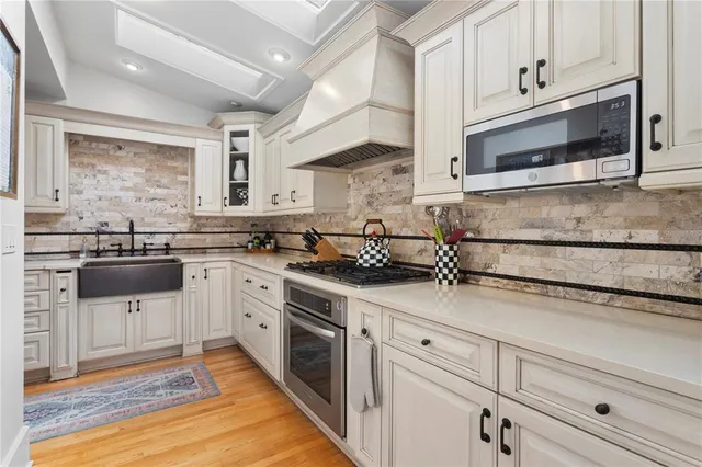 a kitchen with stainless steel appliances granite countertop a sink and a stove