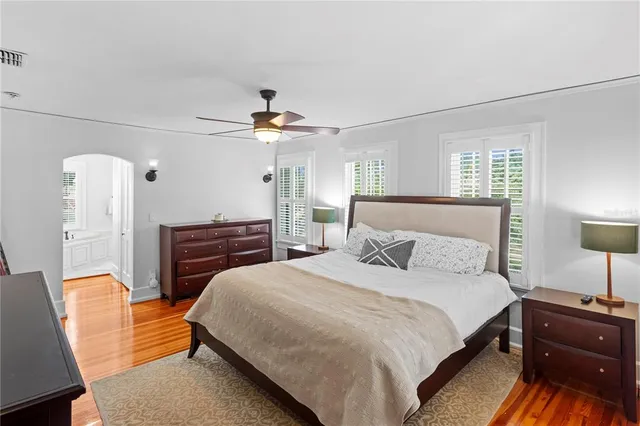a bedroom with a bed lamps and a dresser