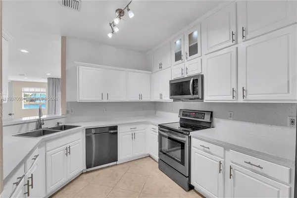 a kitchen with white cabinets stainless steel appliances and sink