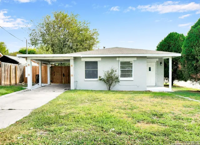 a backyard of a house with table and chairs