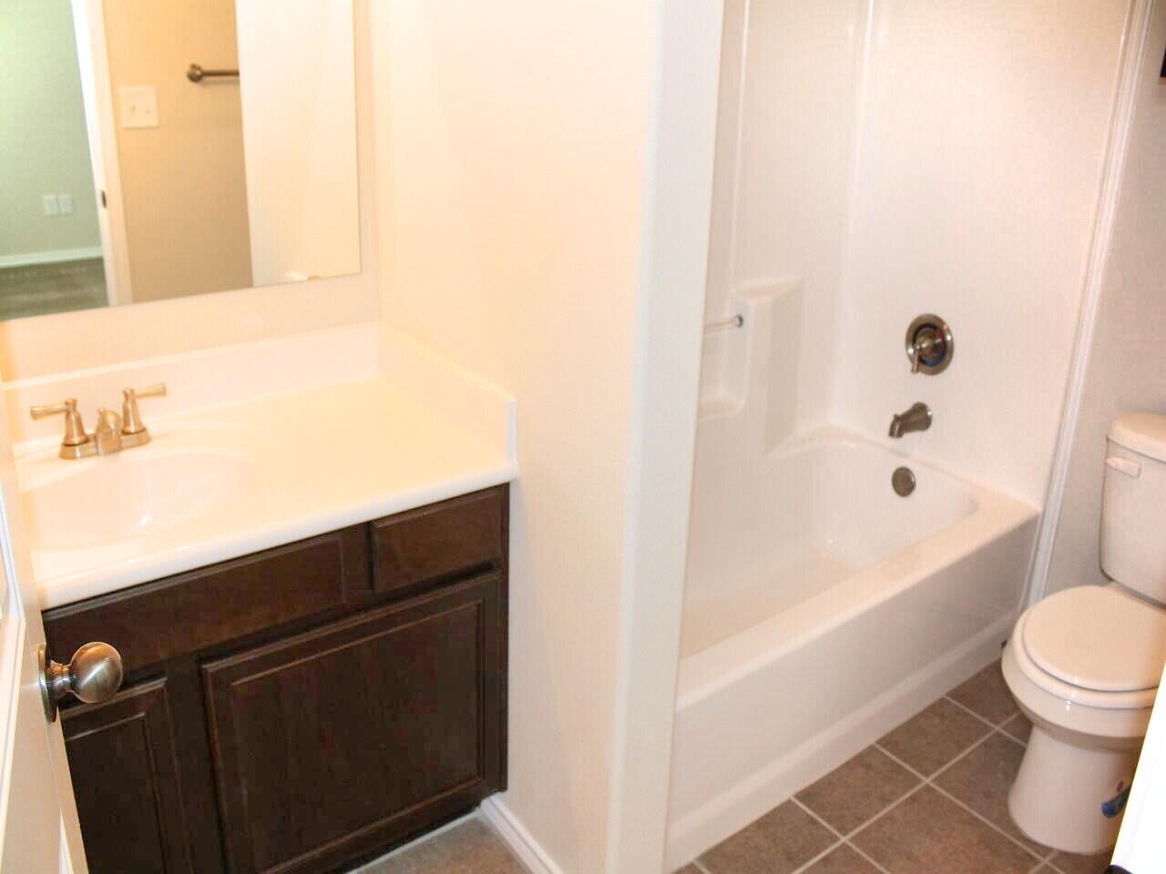 9802 Sherman Avenue Lubbock, TX 79423 - Photo 9 of 9 a bathroom with a bathtub and a toilet