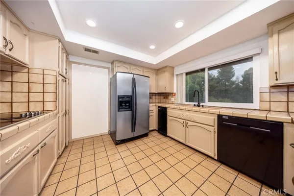 a view of a kitchen with kitchen island a sink wooden floor and a large window