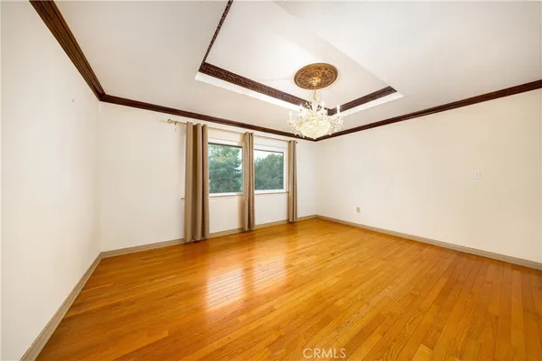 a view of a room with wooden floor fan and windows