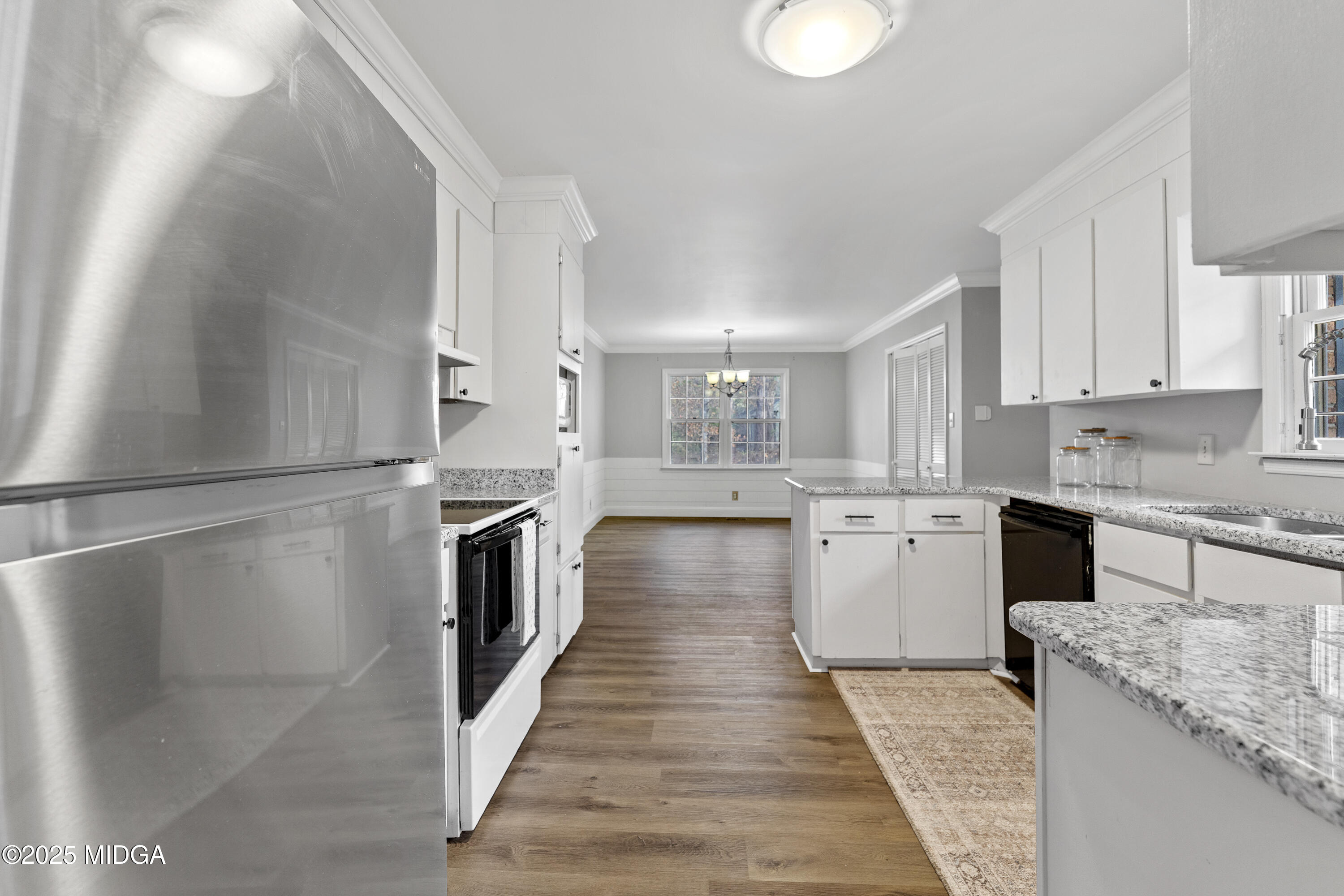 218 Matlock Lane Macon, GA 31210 - Photo 8 of 39 a kitchen with granite countertop a refrigerator a stove and white cabinets with wooden floor
