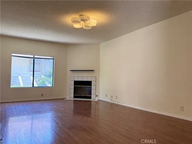 an empty room with wooden floor and chandelier