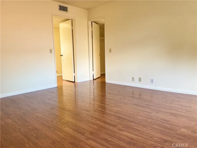 a view of an empty room with wooden floor