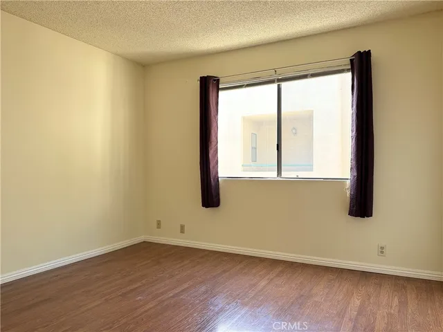 an empty room with wooden floor and a window