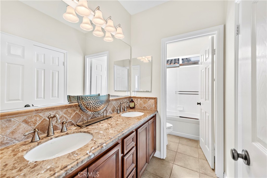 1412 Manera Ventosa San Clemente, CA 92673 - Photo 17 of 21 a bathroom with a granite countertop sink a mirror and a bathtub