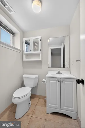 a bathroom with a toilet sink and mirror