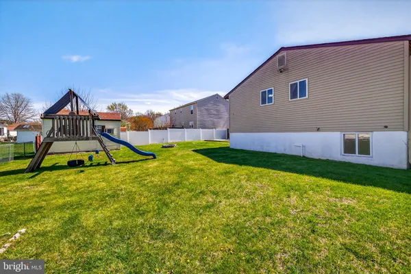 a view of an house with backyard and a tree