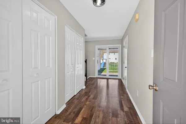 a view of a hallway with wooden floor and closet area