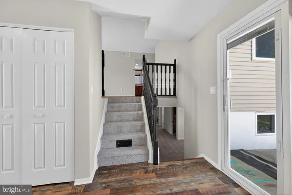 a view of a hallway with wooden floor and entryway
