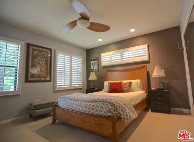 a bedroom with a bed and a large window