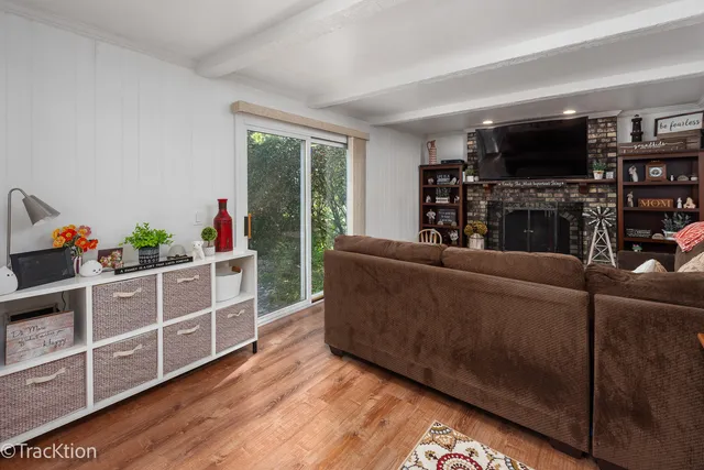a living room with furniture a flat screen tv and a floor to ceiling window