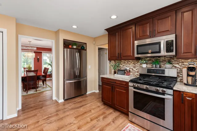 a kitchen with wooden floors and stainless steel appliances