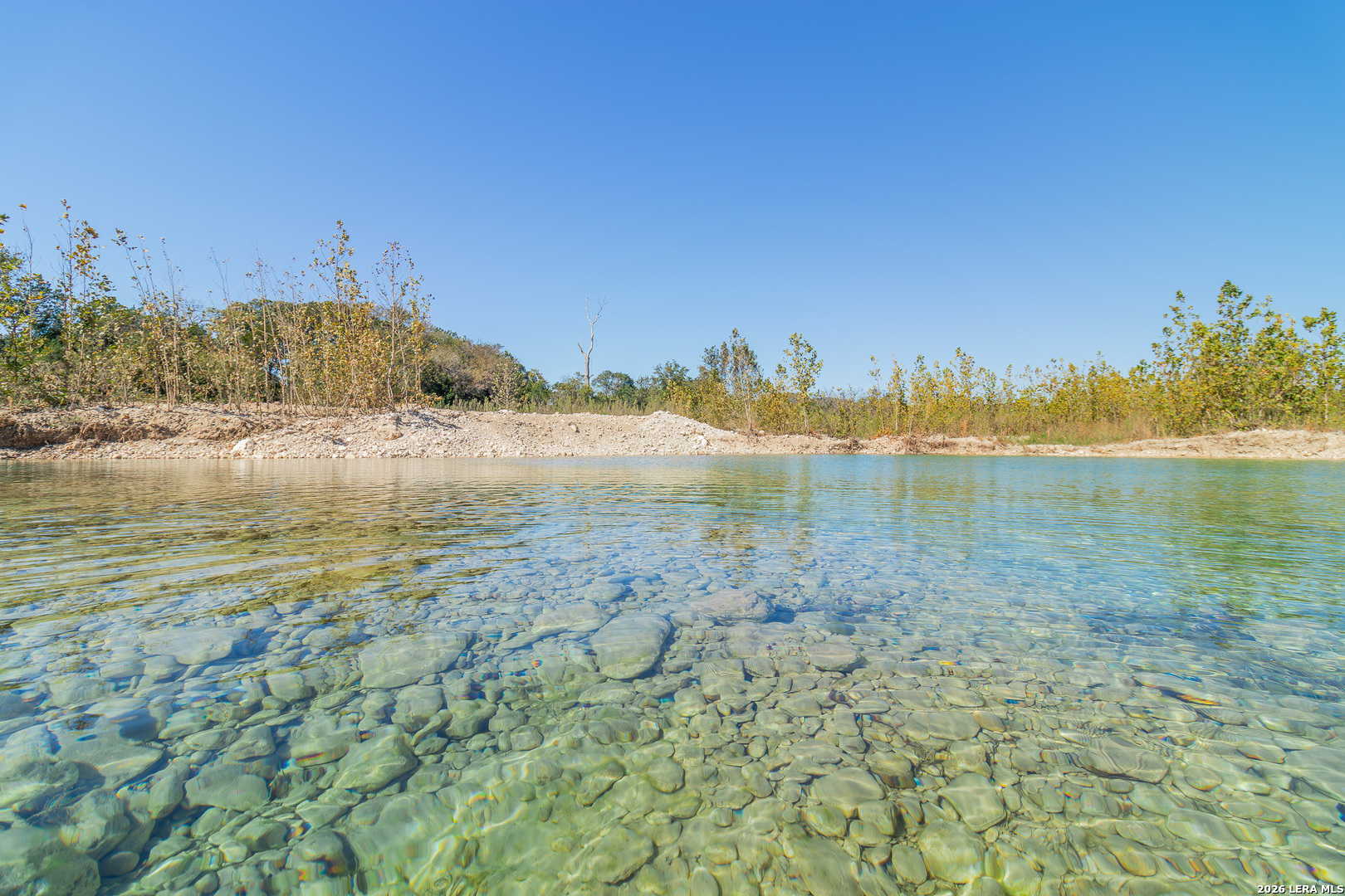 0 Rm 336 Leakey, TX 78873 - Photo 19 of 93 a view of a lake with beach and house in the background