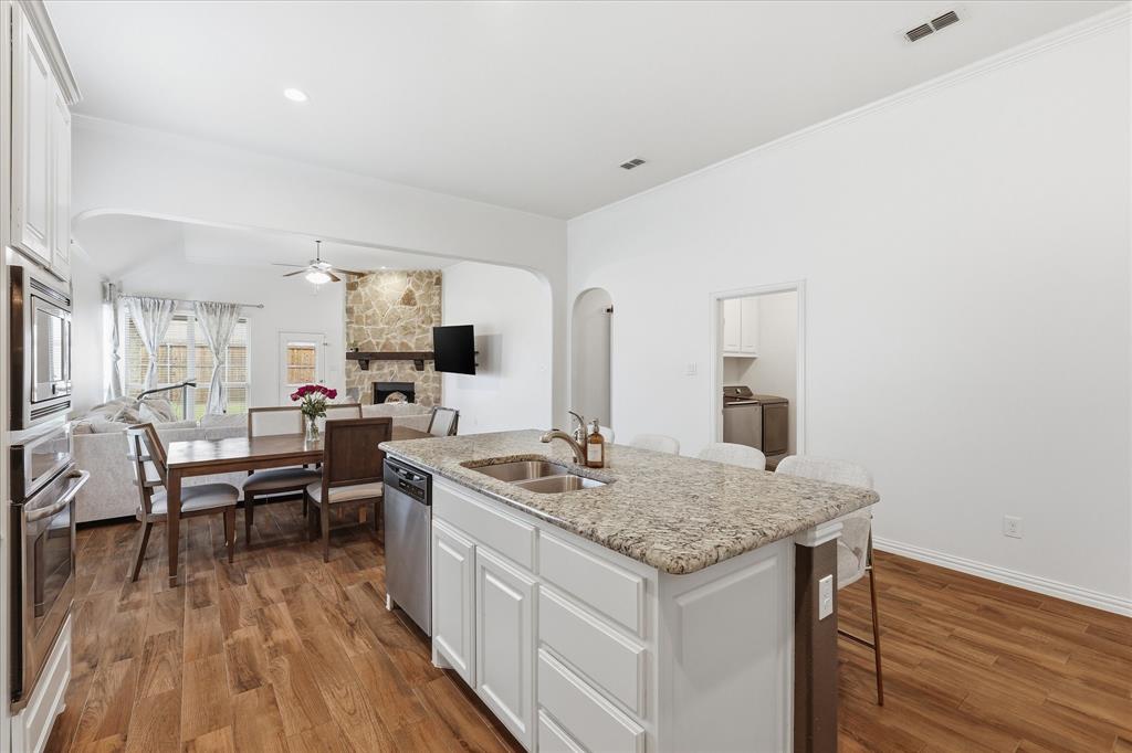 215 Equestrian Road Hickory Creek, TX 75065 - Photo 12 of 36 a open kitchen with stainless steel appliances granite countertop a stove and a wooden floors