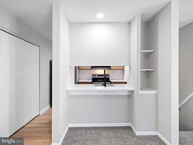 a view of an empty room with a kitchen
