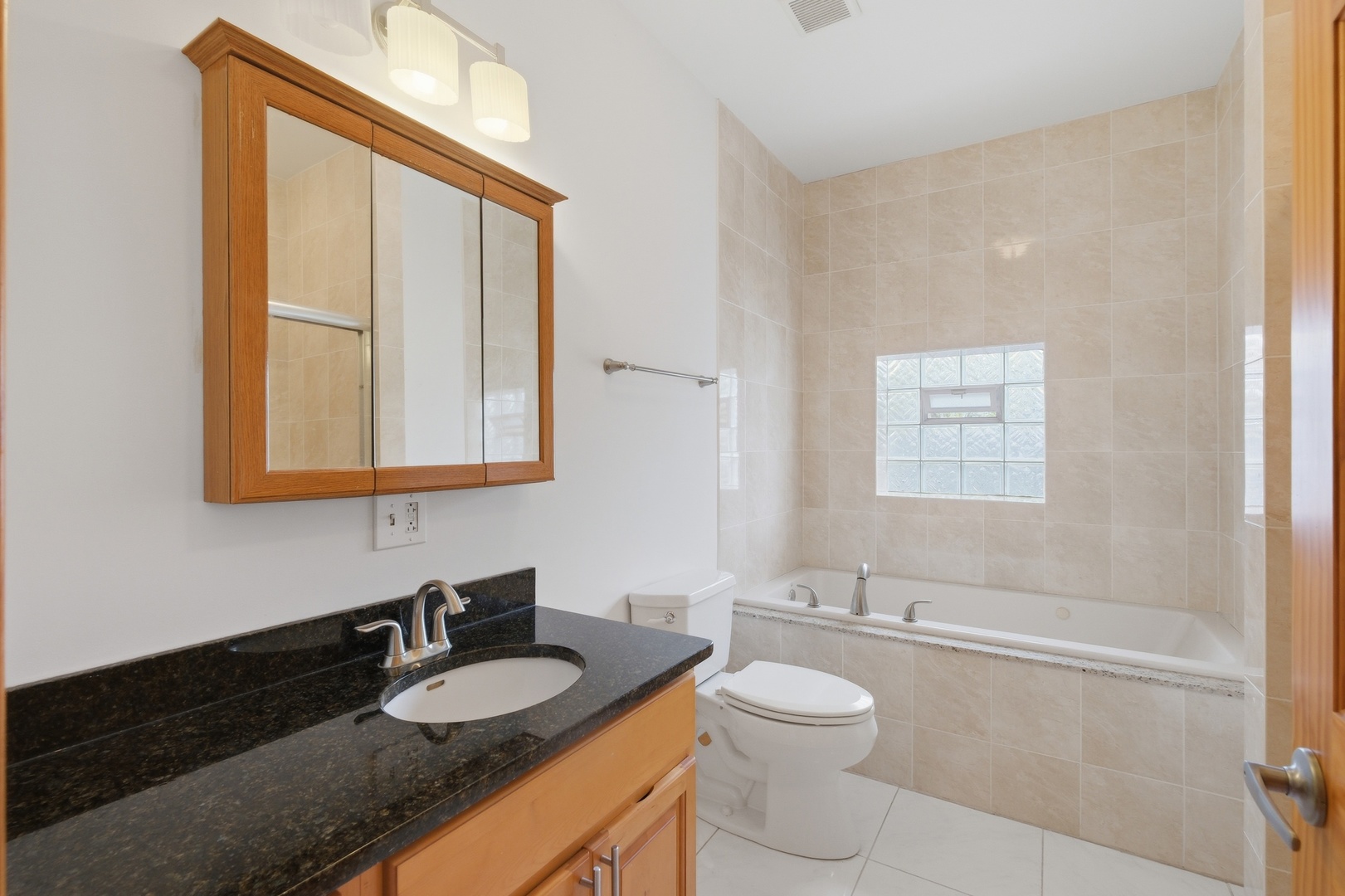 3917 West 60th Street Chicago, IL 60629 - Photo 13 of 34 a bathroom with a granite countertop sink vanity mirror bathtub and toilet