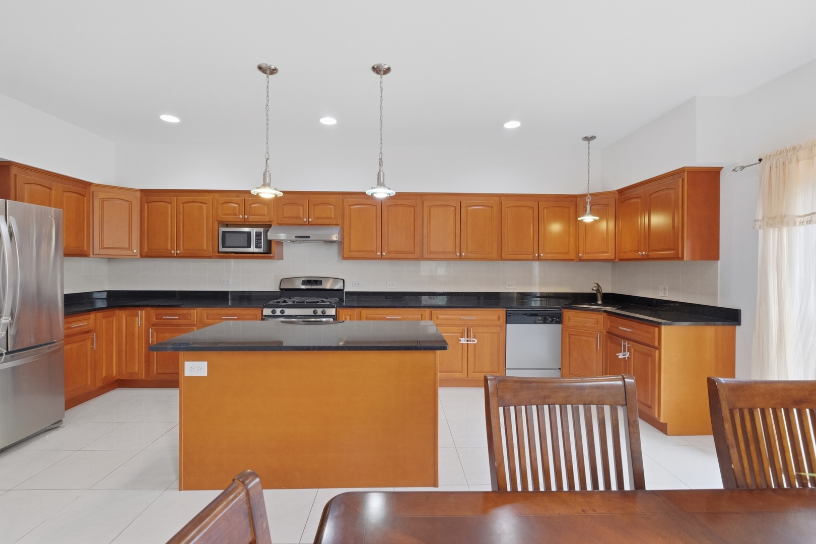 3917 West 60th Street Chicago, IL 60629 - Photo 7 of 34 a kitchen with stainless steel appliances granite countertop a stove a sink and a microwave