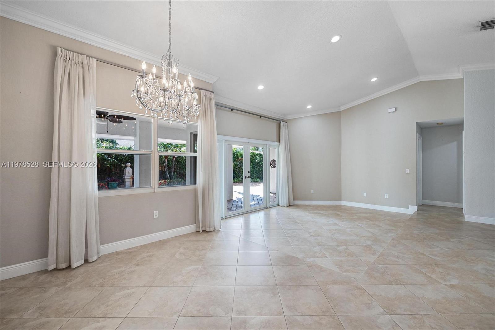 15327 Southwest 55th Terrace Miami, FL 33185 - Photo 7 of 40 a view of an empty room with window and chandelier