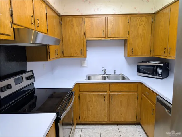 a kitchen with stainless steel appliances a sink a stove and a refrigerator