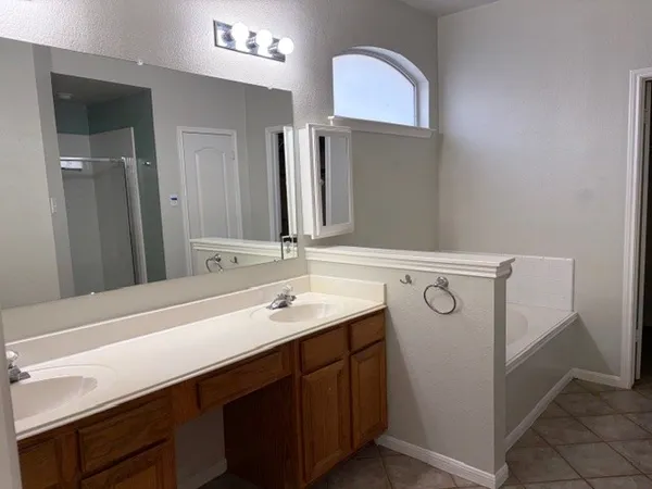 a bathroom with a bathtub sink and mirror