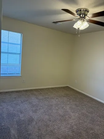an empty room with a chandelier fan