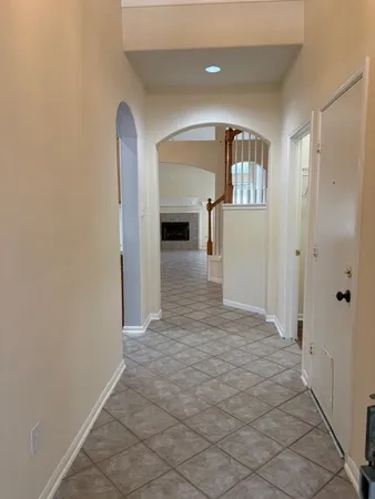 a view of a hallway with wooden floor and a living room