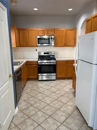 a kitchen with stainless steel appliances granite countertop a refrigerator sink and stove