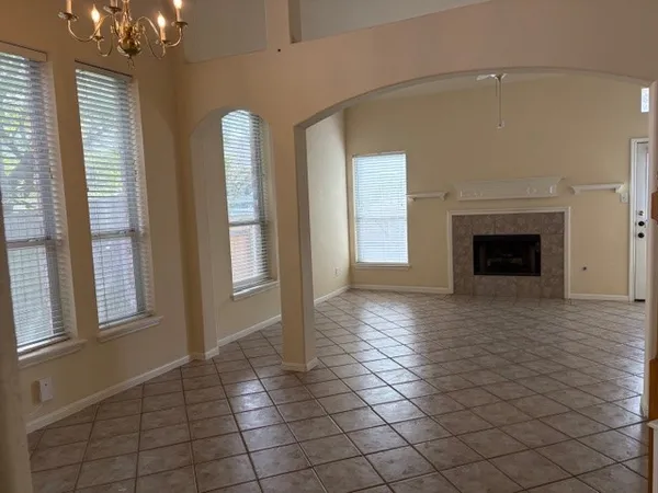 an empty room with windows and fireplace