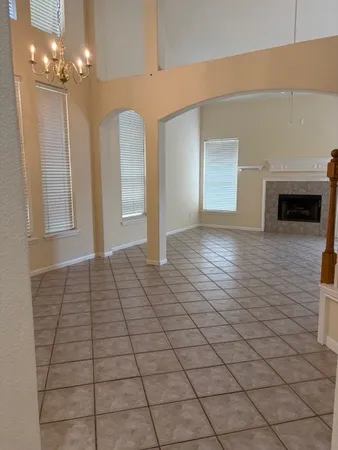a view of empty room with window and chandelier