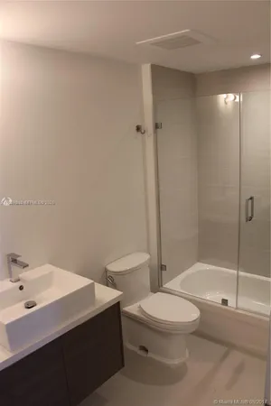 a bathroom with a toilet a sink and shower