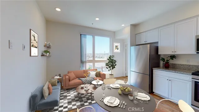 a living room with furniture kitchen and a refrigerator