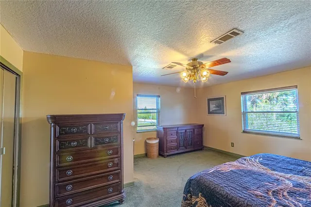 a bedroom with a bed dresser and a window