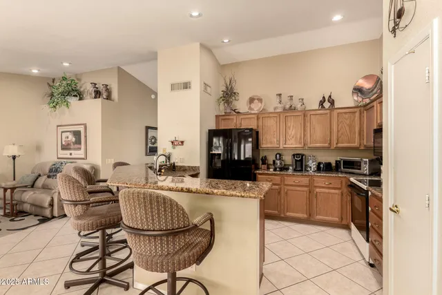 a kitchen with stainless steel appliances kitchen island granite countertop a stove a sink and a refrigerator