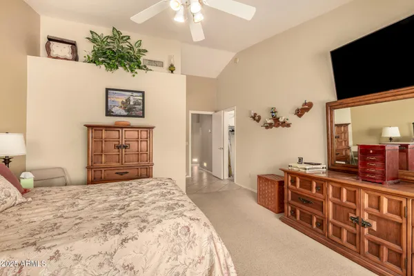 a bedroom with a bed and a flat tv screen on dresser