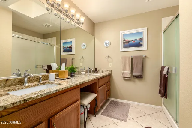 a bathroom with a granite countertop sink a mirror and a shower