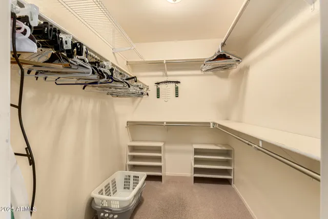 a view of walk in closet with clothes and shoes