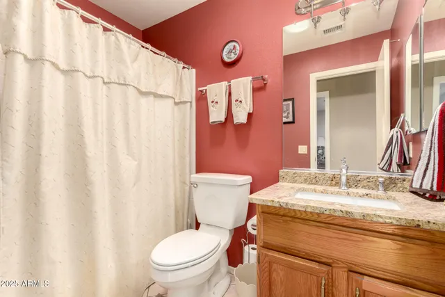 a bathroom with a granite countertop sink mirror vanity and toilet