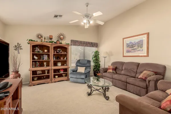 a living room with furniture a chandelier and a flat screen tv