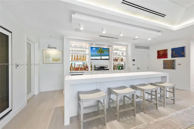 a kitchen with stainless steel appliances kitchen island granite countertop a dining table chairs and a refrigerator