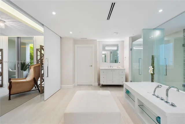 a bathroom with a tub a sink and mirror