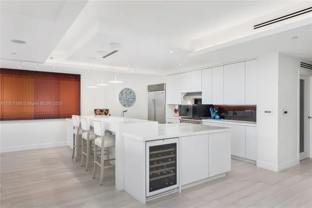 a kitchen with a white cabinets and chairs