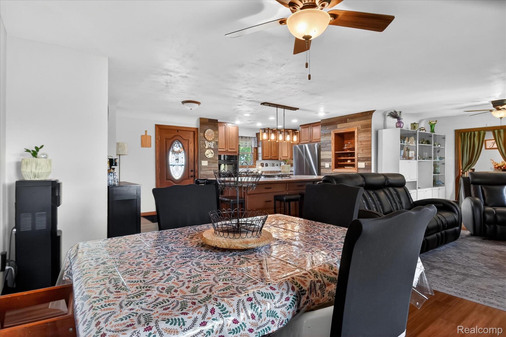 3949 West Burns Line Road Brown City, MI 48416 - Photo 10 of 70 Open concept living area featuring wood-finish flooring, a kitchen with wood cabinetry and stainless steel appliances, and a central island with pendant lighting