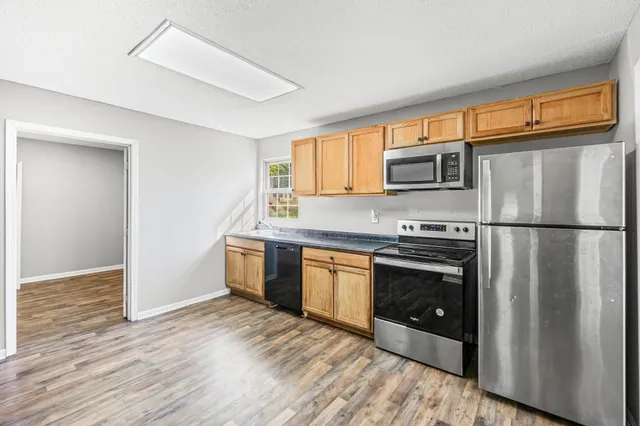 a kitchen with granite countertop a refrigerator stove and microwave