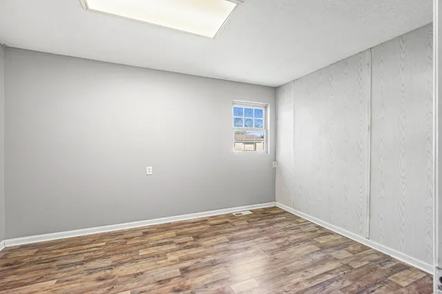 a view of empty room with wooden floor