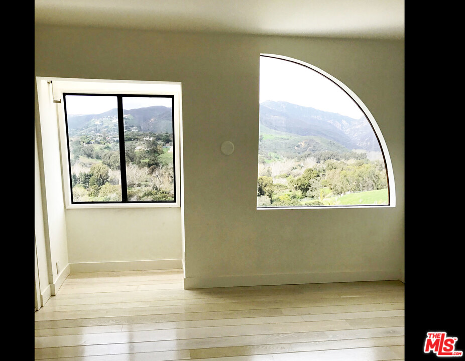 29221 Heathercliff Road, Unit 12 Malibu, CA 90265 - Photo 2 of 8 a view of a big room with wooden floor and a window