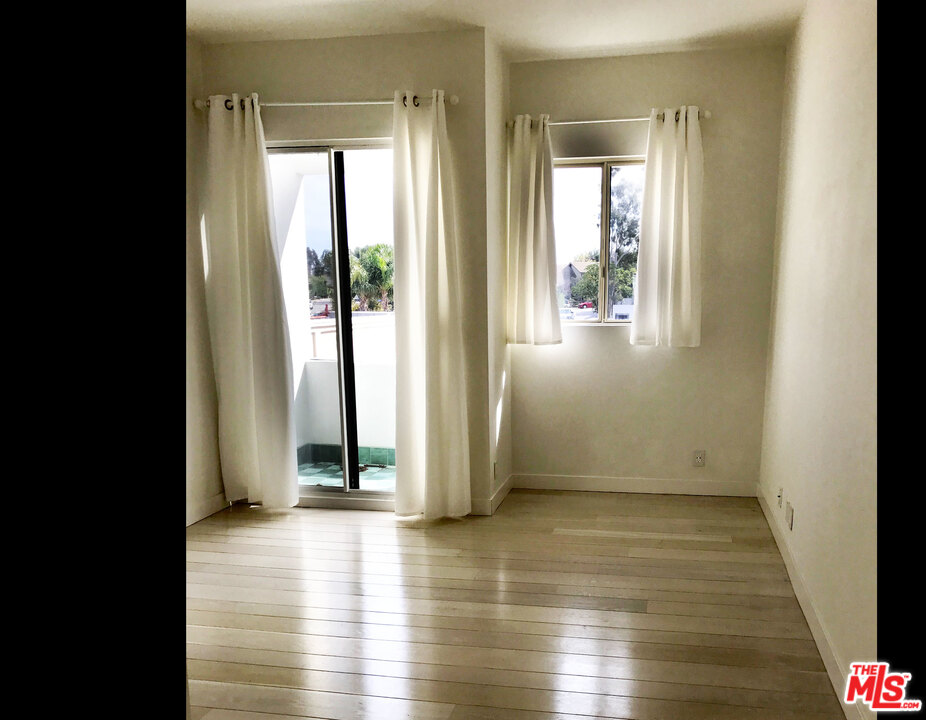 29221 Heathercliff Road, Unit 12 Malibu, CA 90265 - Photo 6 of 8 an empty room with wooden floor and windows